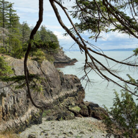 A perspective looking down the rugged cliffs of Cape Roger Curtis, with giant stripes of multicoloured stone.
